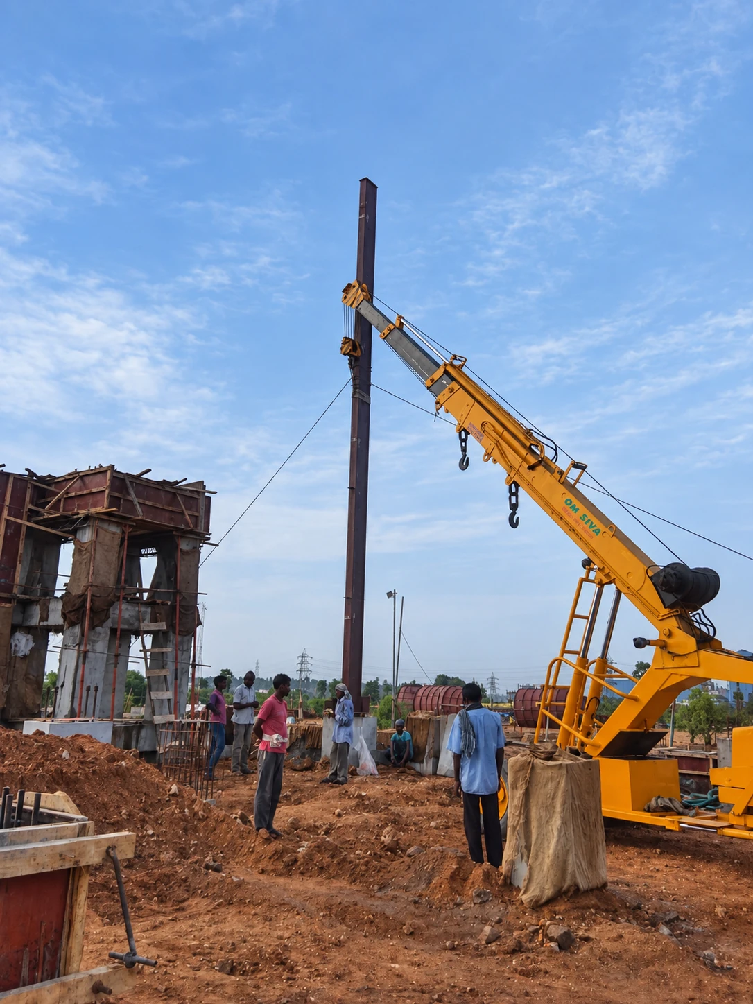 Mobile crane positioning a primary steel column at JS Auto Cast Foundry.